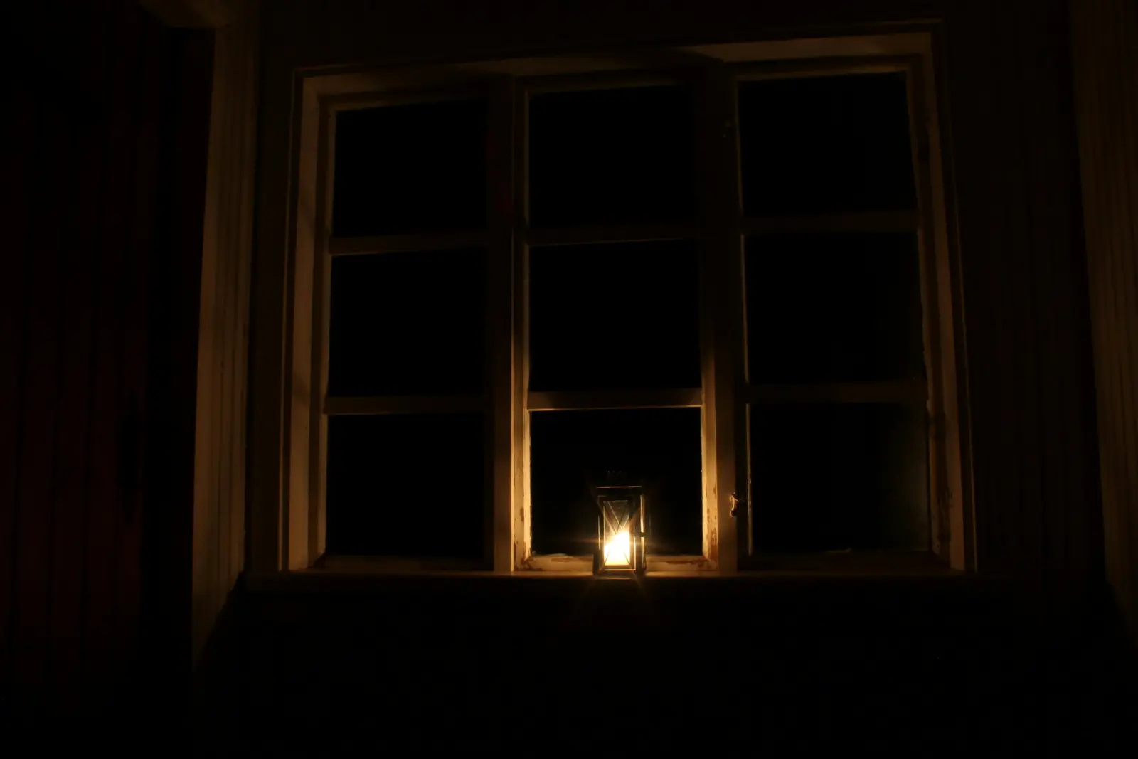 Kaars bij het raam tijdens een stroomstoring
